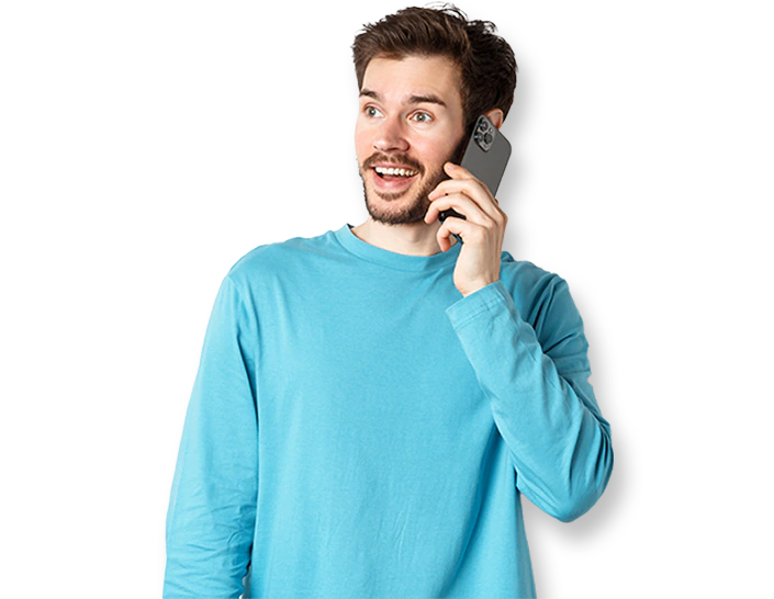 Ein Mann in blauem Sweater hält ein Smartphone an sein Ohr und lächelt. Jetzt bewerbungsgespräch vereinbaren!