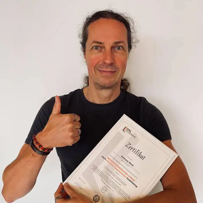 Ernährungsberater Vegan Zertifikat (Englisch) Unser Kunde Andreas hält sein Zertifikat zum Ernährungsberater Vegan in den Händen und hebt einen Daumen hoch.