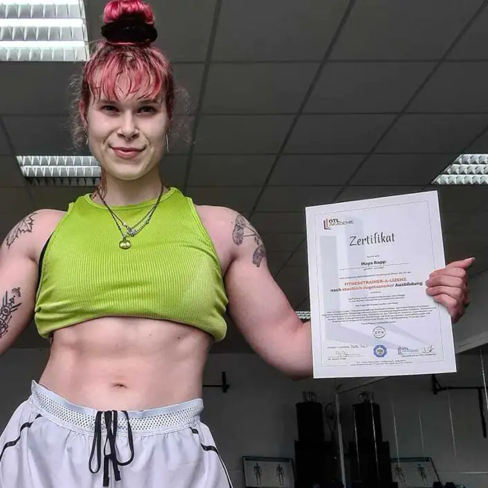 A Lizenz Zertifikat (Englisch) Unsere Kundin Maya präsentiert im Gym stolz ihr Zertifikat zur Fitnesstrainer A-Lizenz