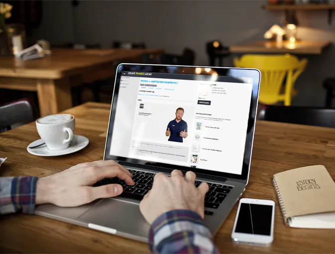 Foto eines Kunden, der in einem Café sitzend ganz flexibel auf seinem Laptop die Inhalte der Ausbildung zum Athletiktrainer erlernt