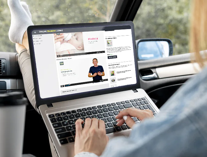 Foto einer Frau, die in einem Auto in einer Pause den Laptop auf ihren Schoß legt und flexibel von unterwegs aus im Online Campus für die Ausbildung zum Ernährungsberater für Säuglinge und Kleinkinder lernt.