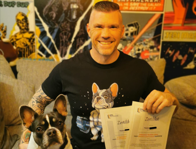 Fitnesstrainer B Lizenz Absolvent zeigt sein Zertifikat 