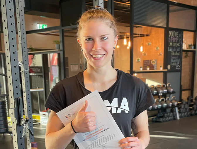 Absolventin Daniela post mit ihrem Athletiktrainer-Zertifikat im Gym
